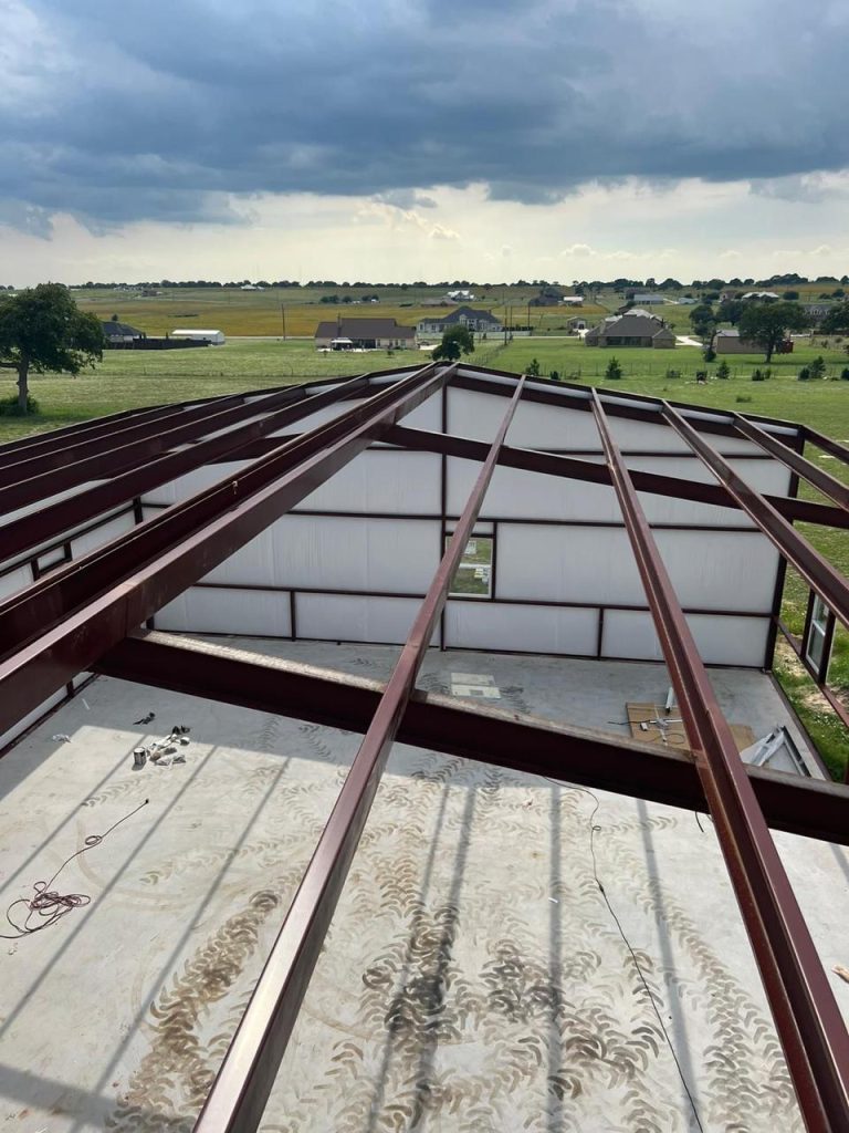 Metal roof panels installed over the red iron frame — Texas Metal Builders